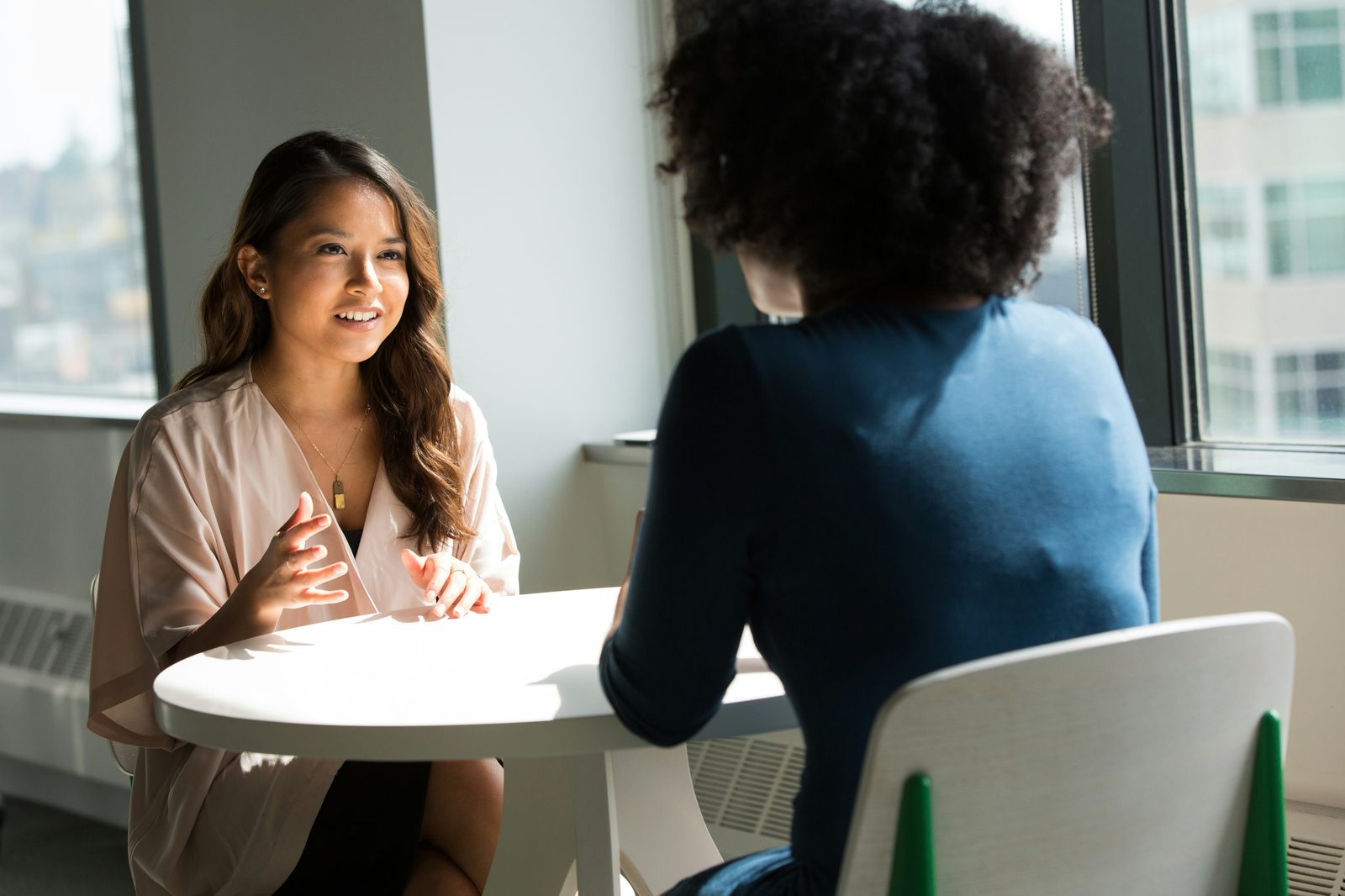 Two colleagues in conversation, one listening closely
