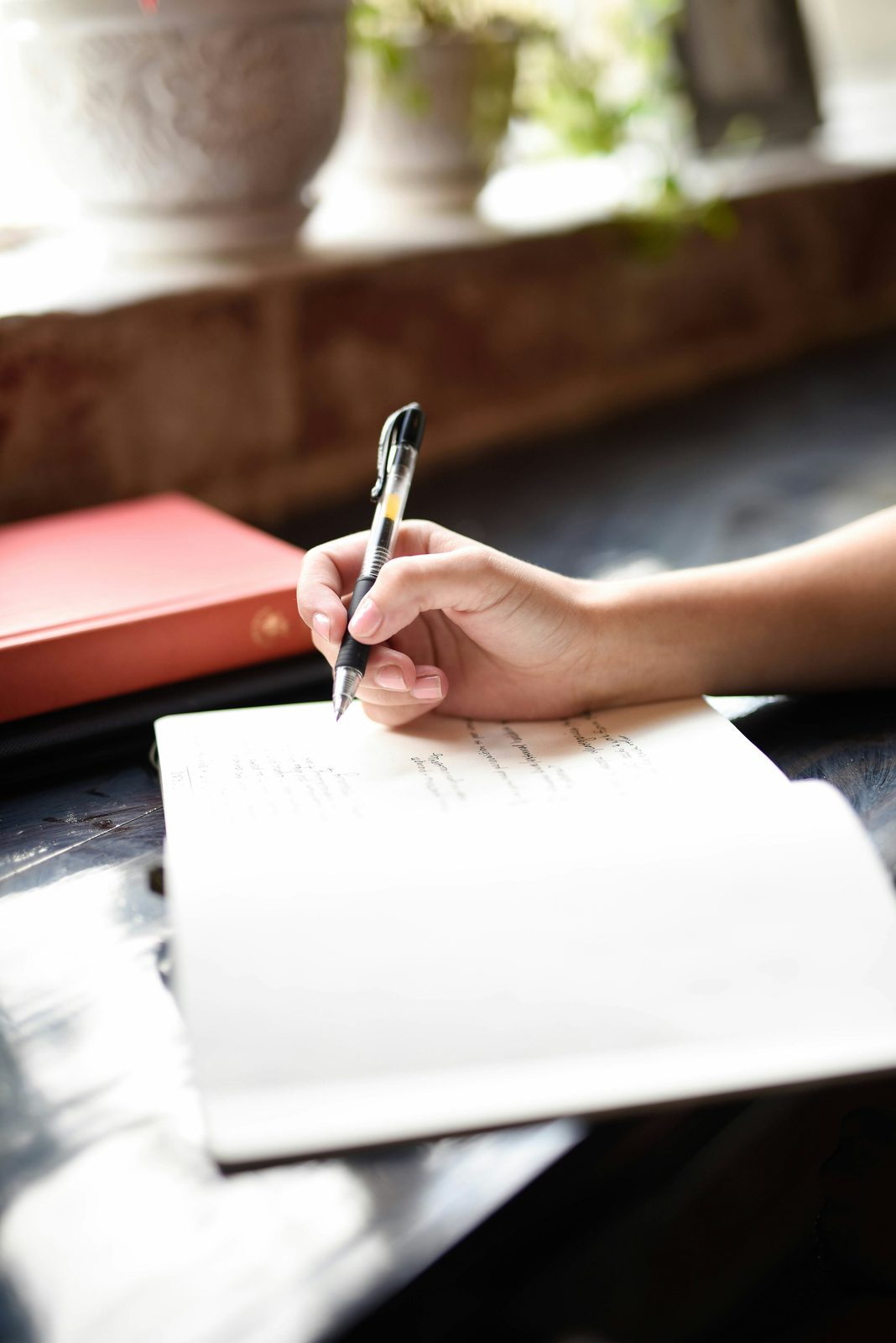 A hand writing in a notebook